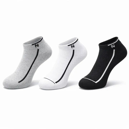 Three pairs of socks in gray, white, and black on a white background