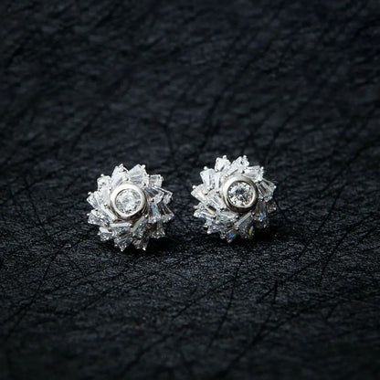 A pair of sterling silver stud earrings featuring a cubic crystal star flower design, set on a black textured background.